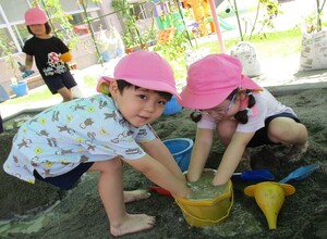 砂場で友達と泥を触って遊んでいます